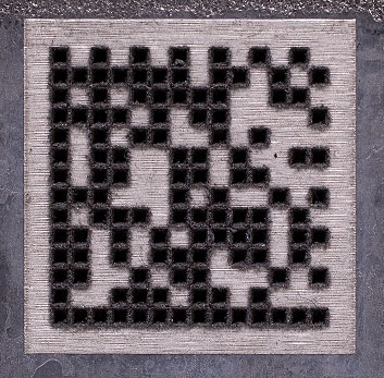 Laser engraved data matrix code with black and white cells.