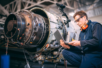 Aircraft engineer repairing and maintaining an airplane jet engine